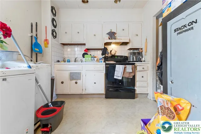 a room with a refrigerator and a stove top oven