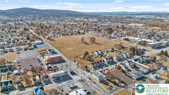 an aerial view of a house with a mountain