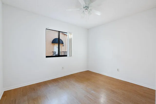 an empty room with a fan and a window