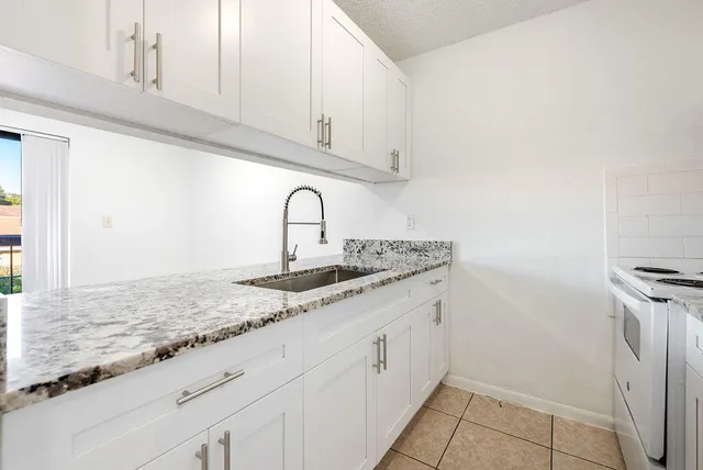 a close view of a sink and dishwasher with white cabinets