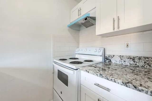 a kitchen with granite countertop cabinets and a stove