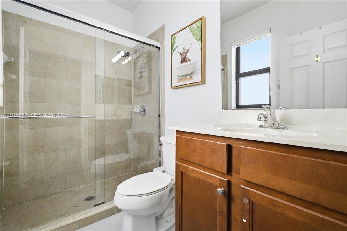 3522 West 86th Terrace Hialeah, FL 33018 - Photo 27 of 35 a bathroom with a shower sink vanity and toilet