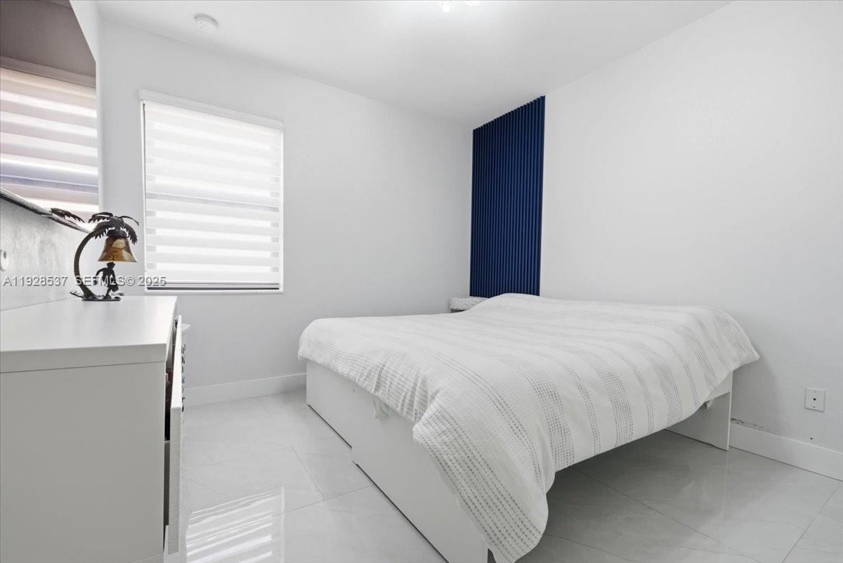 3522 West 86th Terrace Hialeah, FL 33018 - Photo 29 of 35 a bedroom with a bed and a window