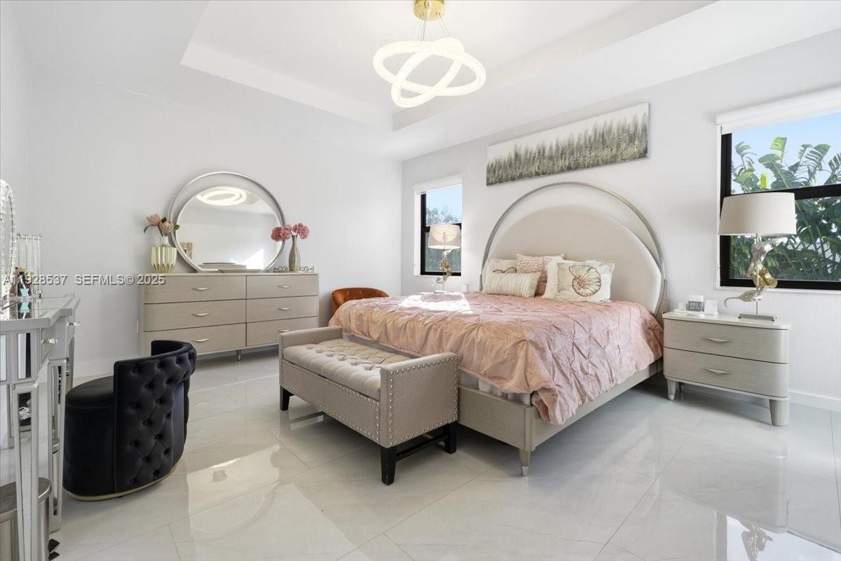 3522 West 86th Terrace Hialeah, FL 33018 - Photo 32 of 35 a bedroom with a bed and a chandelier