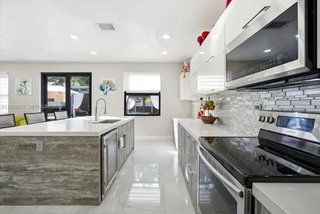 a kitchen with stainless steel appliances kitchen island granite countertop a sink and cabinets