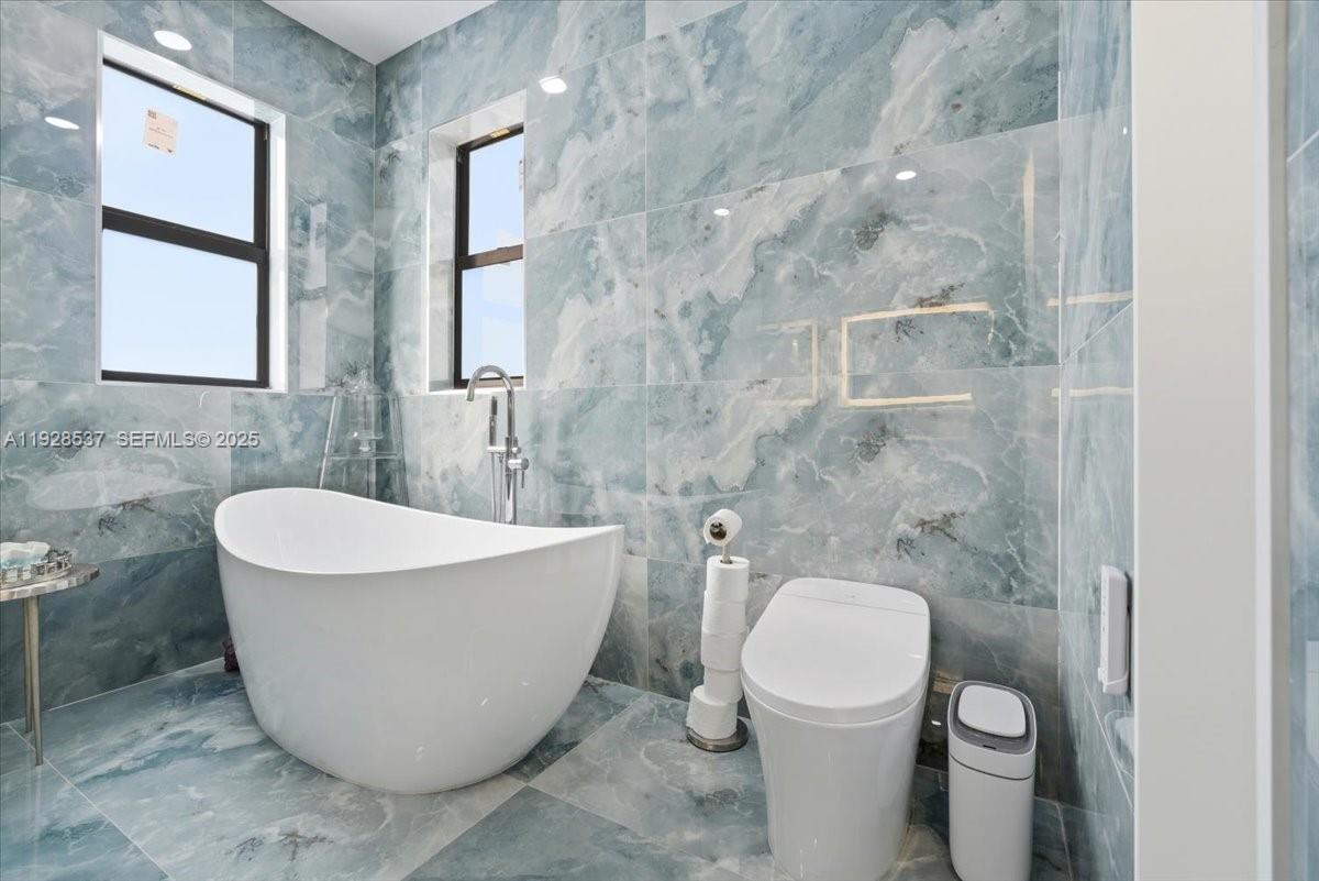 3522 West 86th Terrace Hialeah, FL 33018 - Photo 9 of 35 a white bath tub sitting next to a white toilet