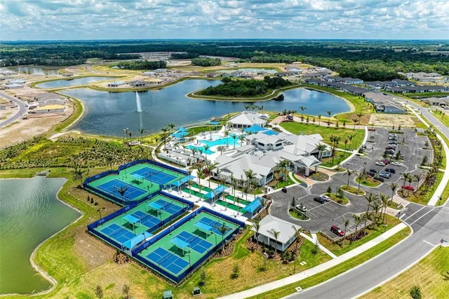 a living room with couches and a flat screen tv with kitchen view