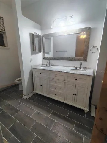 a spacious bathroom with a double vanity sink a mirror and a