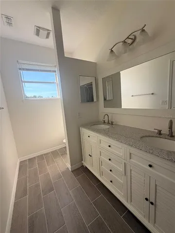 a spacious bathroom with a granite countertop sink a mirror and a