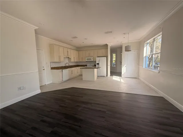 a view of a kitchen with wooden floor and electronic appliances