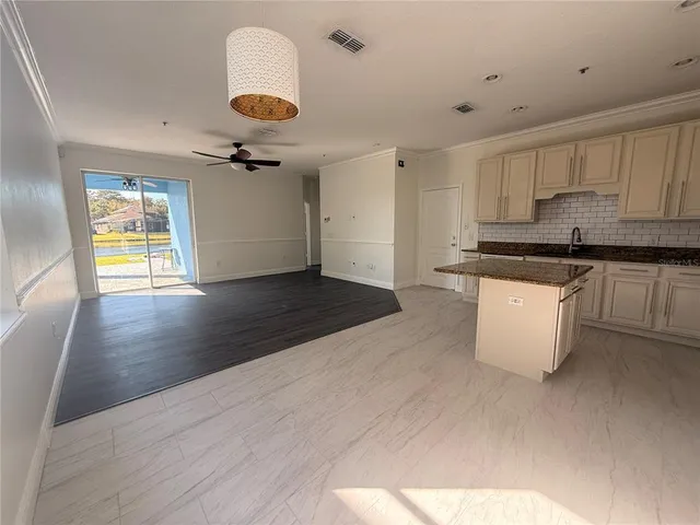 a kitchen with granite countertop a stove a sink and a refrigerator