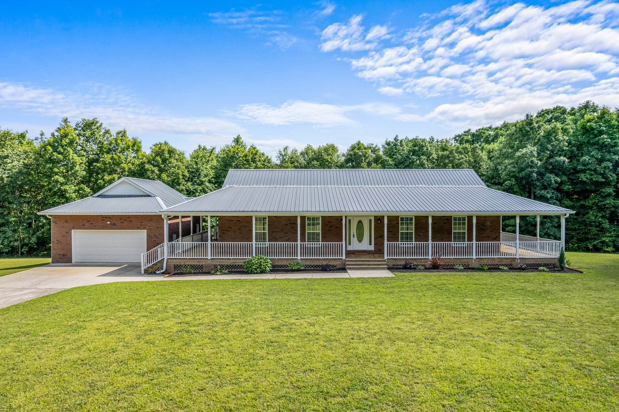 a front view of a house with a garden and trees