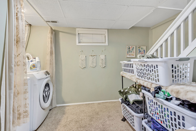 65 West 700 North Bountiful, UT 84010 - Photo 23 of 29 Dedicated laundry area featuring a front-loading washing machine, light green walls, and carpet flooring