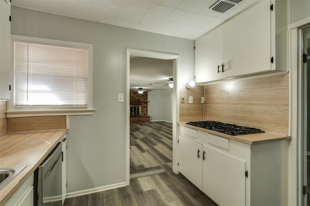 400 South Bailey Street Electra, TX 76360 - Photo 12 of 36 a kitchen with white cabinets and appliances