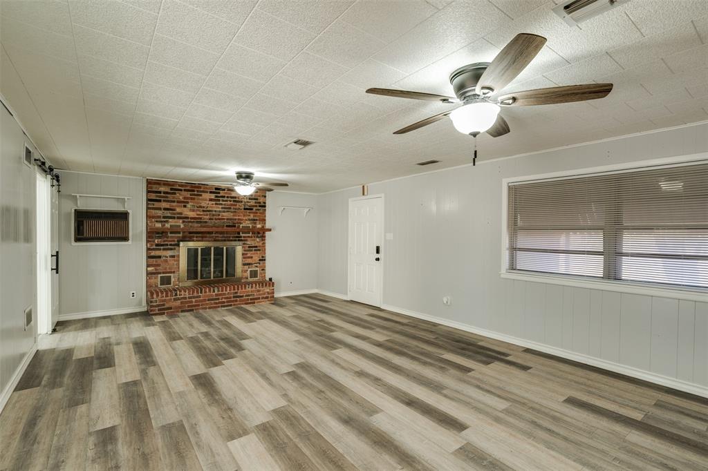 400 South Bailey Street Electra, TX 76360 - Photo 13 of 36 en empty room with windows and fireplace