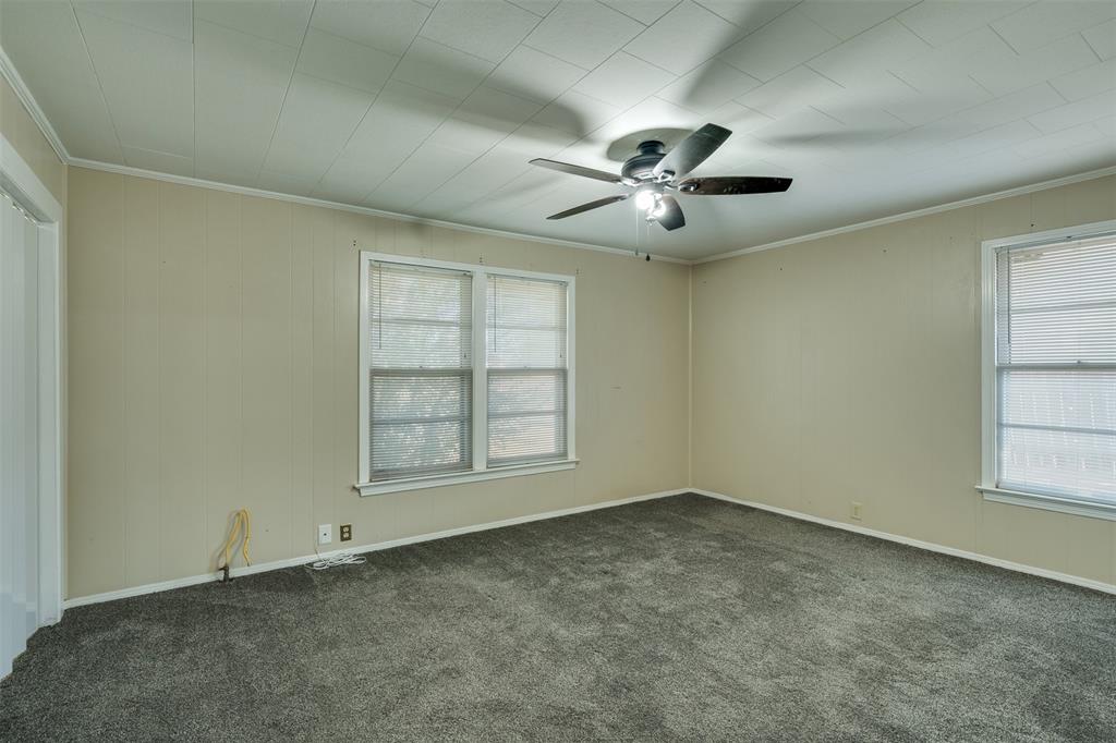 400 South Bailey Street Electra, TX 76360 - Photo 19 of 36 an empty room with chandelier fan and windows