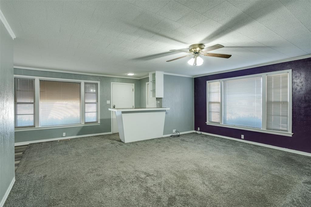 400 South Bailey Street Electra, TX 76360 - Photo 7 of 36 an empty room with chandelier fan and windows