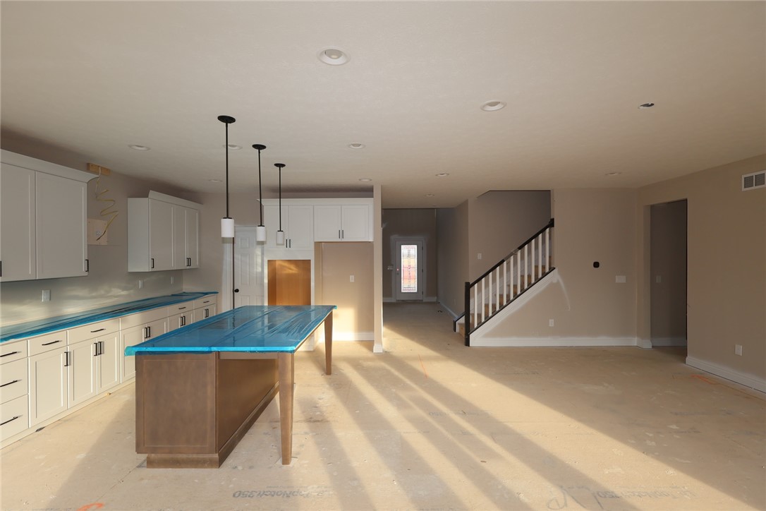 240 Tilly Court, Unit 5 Springboro, OH 45066 - Photo 10 of 26 This bright, spacious area features a well-appointed kitchen and a welcoming staircase, perfect for everyday living.
