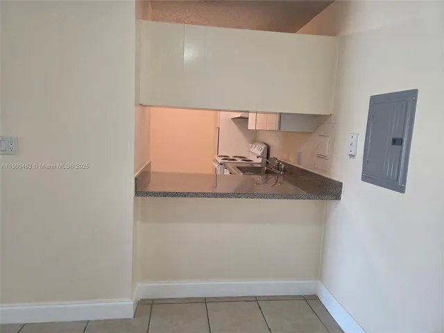 a kitchen with granite countertop white cabinets and white appliances