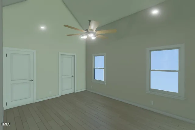 an empty room with wooden floor closet and windows
