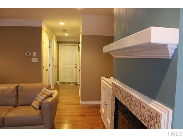 6924 Saxby Court Raleigh, NC 27613 - Photo 4 of 19 a hallway with a couch and wooden floor