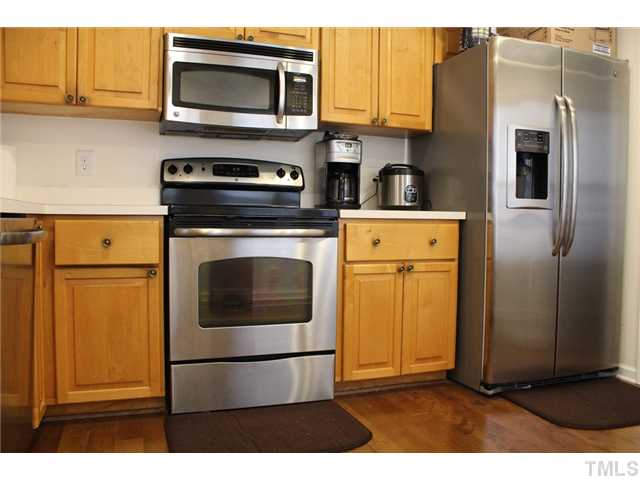 6924 Saxby Court Raleigh, NC 27613 - Photo 8 of 19 a kitchen with stainless steel appliances granite countertop a stove a microwave and a refrigerator