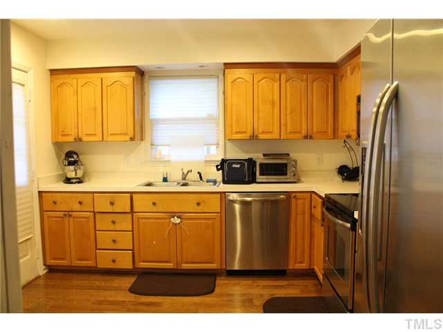 6924 Saxby Court Raleigh, NC 27613 - Photo 9 of 19 a kitchen with a refrigerator sink and cabinets