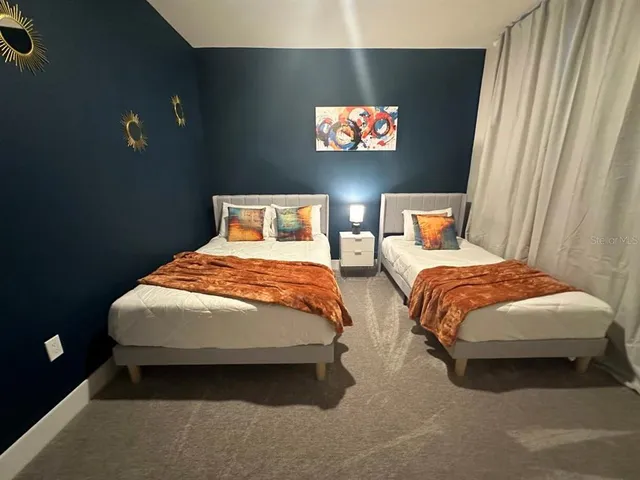a bedroom with two beds and a flat screen tv