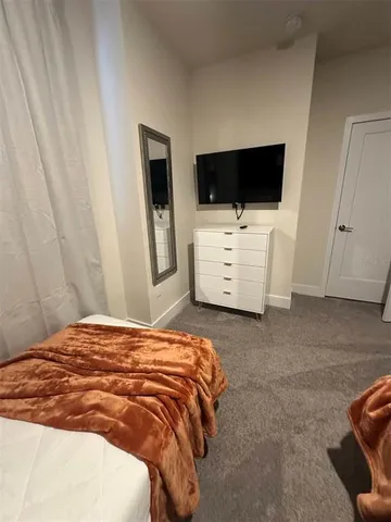 a bedroom with a bed and flat screen tv
