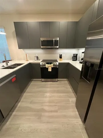 a large kitchen with a stove top oven and sink