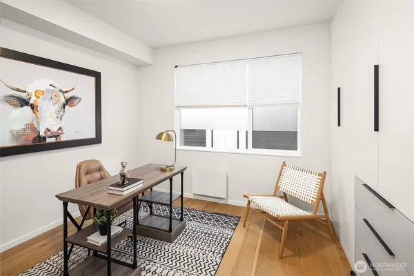 a view of a workspace with furniture and a window