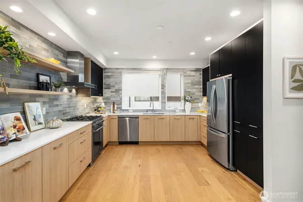 a large kitchen with a sink stainless steel appliances and cabinets