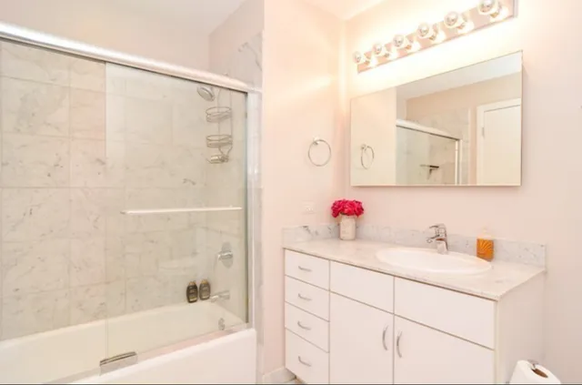 a bathroom with a bathtub sink vanity and mirror
