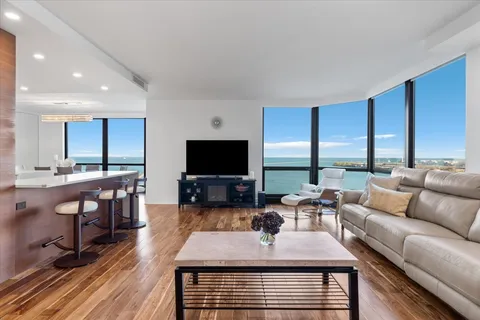 a living room with furniture a flat screen tv and a large window