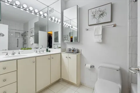 a bathroom with a sink a toilet and a large mirror
