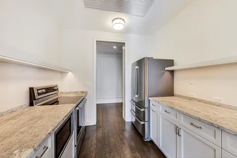 a kitchen that has a sink a stove and a refrigerator