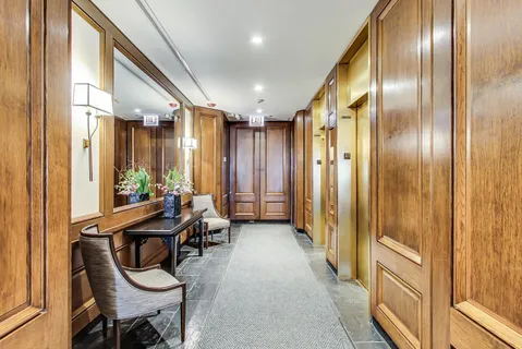 a view of a hallway with furniture and windows