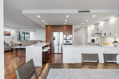 a large white kitchen with lots of counter space and furniture