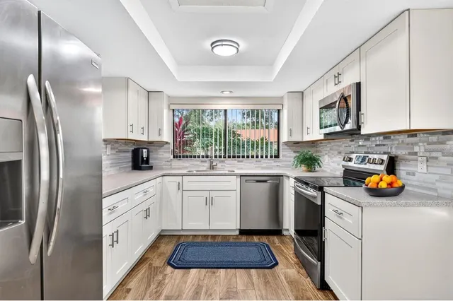 a kitchen with stainless steel appliances a stove a sink and a refrigerator