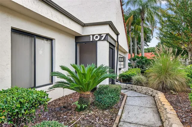 a view of a house with a yard and potted plants