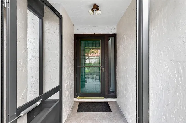 a backyard of a house with table and chairs plants and large tree