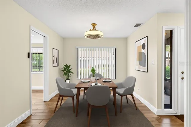 a dining room with furniture a chandelier and wooden floor