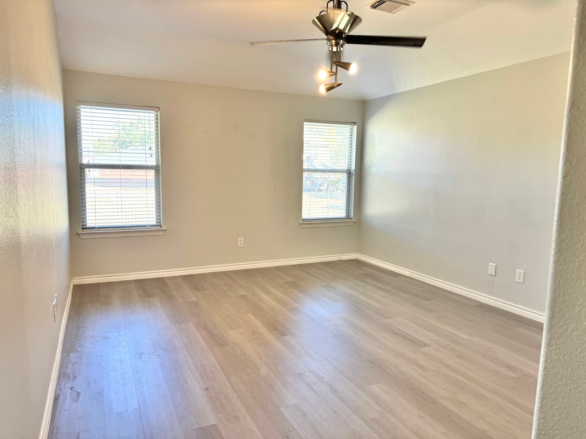 8603 Malardcrest Drive Humble, TX 77346 - Photo 11 of 21 an empty room with wooden floor fan and windows