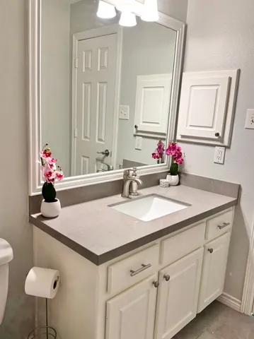 a bathroom with a sink vanity and a mirror