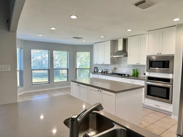 a kitchen with a sink a counter top space appliances and cabinets