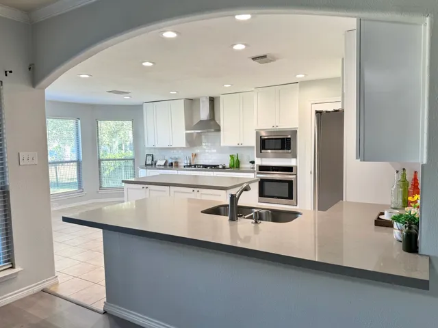 a kitchen with stainless steel appliances a sink a stove a microwave and a refrigerator