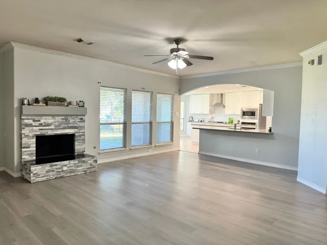 a view of an empty room with a fireplace and a window