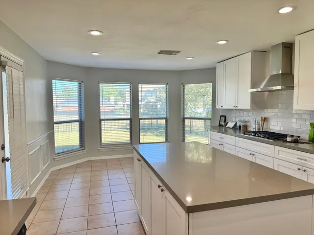 a large kitchen with stainless steel appliances granite countertop a large window