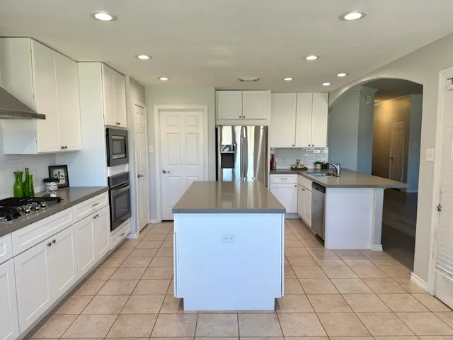 a kitchen with stainless steel appliances granite countertop a stove top oven a sink a counter top space and cabinets