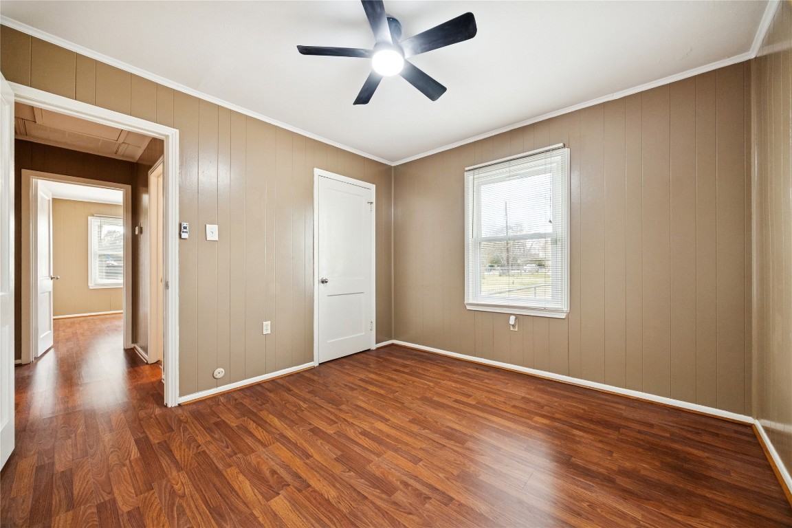12537 Terrance Street Houston, TX 77085 - Photo 13 of 27 This secondary bedroom room features laminate flooring, neutral brown paneled walls, and a ceiling fan. The windows provide natural light and a spacious closet, offering a cozy and functional space.